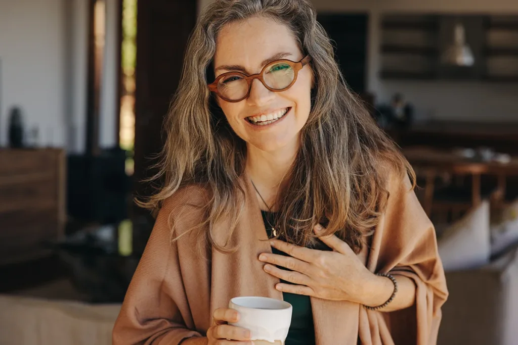 An older adult women with glasses, smiling kindly